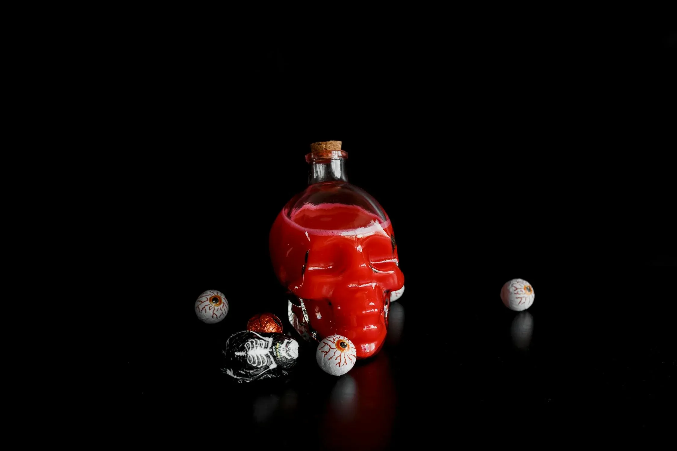 Cocktail with red liquid in a skeleton glass with eye balls.